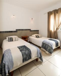 Duas camas num quarto com paredes brancas em Macchie e Fiori em Pianottoli-Caldarello