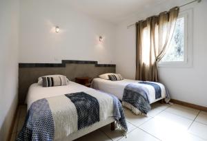 two beds in a room with a window at Macchie e Fiori in Pianottoli-Caldarello
