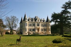 a gazelle standing in front of a large house at Château de la gauderie in Notre-Dame-de-Sanilhac