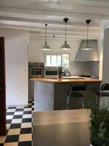 a kitchen with a counter and two chairs in it at Maison de village in Velleron