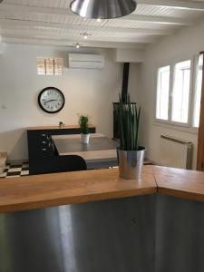 a kitchen with a counter with a clock on the wall at Maison de village in Velleron