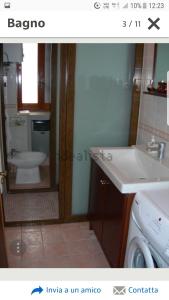 een badkamer met een wastafel, een toilet en een spiegel bij luxury lake in Villetta Barrea