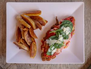 a white plate with a sandwich and french fries at Macchie e Fiori in Pianottoli-Caldarello