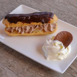 a doughnut with chocolate icing and a spoon of whipped cream at Macchie e Fiori in Pianottoli-Caldarello