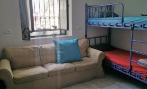 a bedroom with a blue couch and blue pillows at German Colony Guest House- Private and Dorm rooms in Haifa