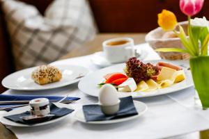 einen Tisch mit Tellern und einer Tasse Kaffee in der Unterkunft Hotel zur Schloss-Schmiede in Kühbach