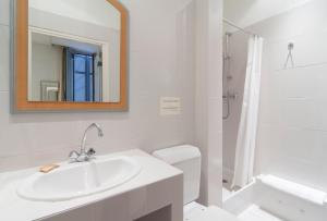 a white bathroom with a sink and a mirror at Hôtel P.L.M. in Cannes