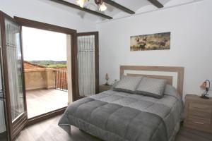 een slaapkamer met een bed en een balkon bij Casa Sierra de Guara in Adahuesca