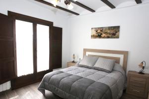 a bedroom with a large bed and two windows at Casa Sierra de Guara in Adahuesca