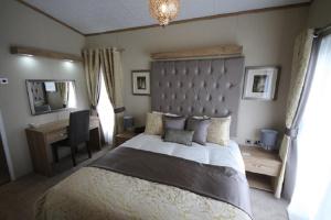 a bedroom with a large bed and a desk at Tweed Lodge in Perth