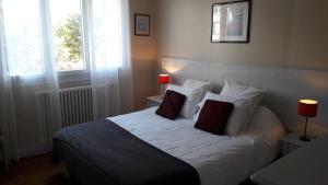 een slaapkamer met een bed met witte lakens en kussens bij Ty Lireu in Concarneau
