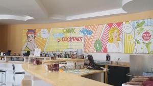 a restaurant with colorful posters on the wall at Green Garden Club in Briatico