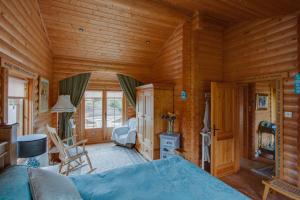 Dormitorio de una cabaña de madera con cama en Balnabrechan Lodge en Arbroath