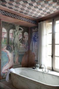a bath tub in a bathroom with a mural at Casa9 Hôtel in Thuir