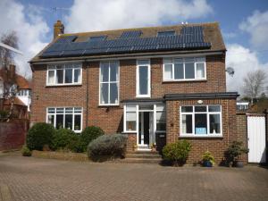 una casa de ladrillo con paneles solares en el techo en De La Warr Guest House en Bexhill