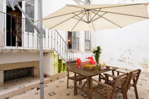 - une table et des chaises avec un parasol sur la terrasse dans l'établissement Bairro Alto 3 Bedroom Patio Flat!, à Lisbonne