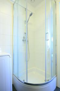 ソポトにあるVictus Apartamenty, Apartament Tangoのバスルーム(ガラスドア付きのシャワー付)