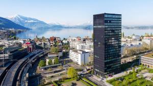 una città con un palazzo alto accanto a un corpo d'acqua di Park Tower City View Apartments a Zugo