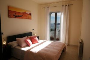 a bedroom with a bed with pink pillows and a window at Villa hortencia in Tarragona