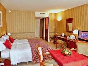 Pokój hotelowy z łóżkiem i biurkiem w obiekcie Golden Tulip Hotel de’ Medici w Brugii