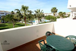 a balcony with a table and chairs and a swimming pool at Residencial Carrajolilla in Chiclana de la Frontera