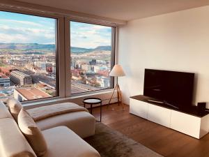 a living room with a television and a large window at Park Tower City View Apartments in Zug