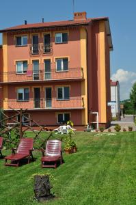 a building with chairs in the grass in front of it at Willa Dorotka in Busko-Zdrój