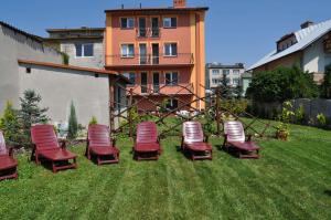 a group of chairs sitting in the grass at Willa Dorotka in Busko-Zdrój