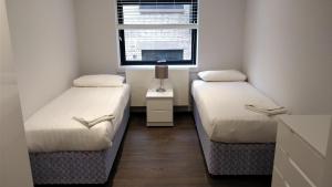 a small room with two beds and a window at Access Tower Hill in London