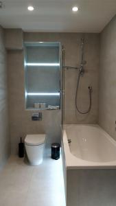 La salle de bains est pourvue d'une baignoire, de toilettes et d'une douche. dans l'établissement Access Tower Hill, à Londres