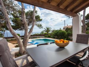 a table with a bowl of oranges on a patio at Villa Estrella Sea View in Cala Figuera