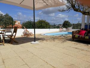アルブフェイラにあるCasa Antonica -private poolのスイミングプールの隣にパラソル付きのパティオ