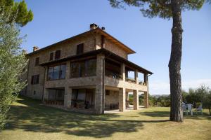 stary ceglany dom z drzewem przed nim w obiekcie Agriturismo San Fedele w mieście Perugia