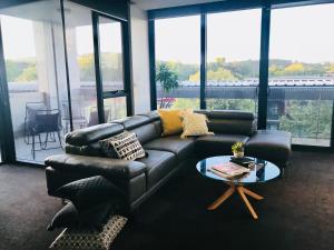 a living room with a leather couch and a table at The Botanical 201 in Albury