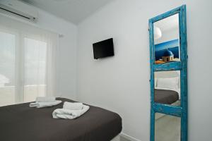 a bedroom with a blue bunk bed and a mirror at Corrado Caldera Apartments in Fira