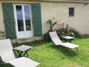 dwa krzesła i stół przed domem w obiekcie Maison de Campagne w mieście Sarragia