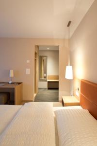 a hotel room with two beds and a desk at OCHSEN LODGE by Ochsen Lenzburg in Lenzburg