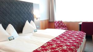 Stadtoase Kolping Hotel tesisinde bir odada yatak veya yataklar