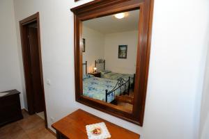 a mirror on a wall with a bed in a room at Agriturismo San Fedele in Perugia