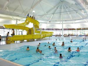 a group of people swimming in a swimming pool at Macdonald Highlands Hotel at Macdonald Aviemore Resort in Aviemore