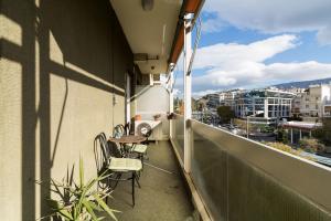 a balcony with chairs and a table on a building at Two-Bedroom Apartment -Kallirrois Athens in Athens