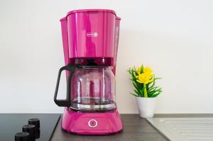 a pink blender sitting on a counter with a flower at Apartment Family Time in Umag