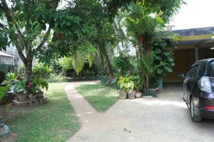 a car parked in front of a house with trees at Juliyanvilla in Kandy