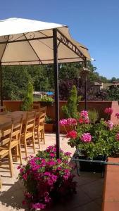 um pátio com uma mesa, cadeiras e flores em Farm stay Agriturismo la Borgaccia em Baiso