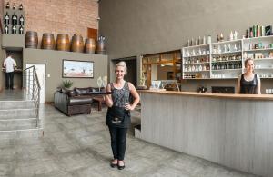 a woman standing in front of a bar at HERMS Restaurant & Boutique Hotel in Port Elizabeth
