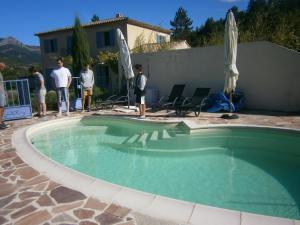 a group of people standing around a swimming pool at La Gravelière in Rémuzat