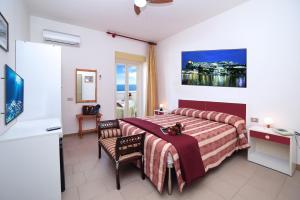 una camera d'albergo con letto, tavolo e sedia di Hotel Peschici a Peschici