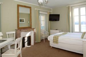 1 dormitorio con cama, escritorio y espejo en Villa Gulf Stream, en Dinard