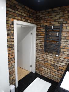 una parete di mattoni con una porta bianca in una stanza di Black&White Apartment- Wierzbowa 5 a Poznań