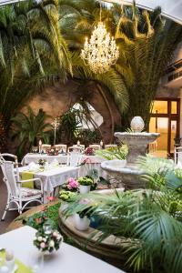 ein Restaurant mit Tischen, einem Brunnen und einem Kronleuchter in der Unterkunft Golden Royal Boutique Hotel & Spa in Košice